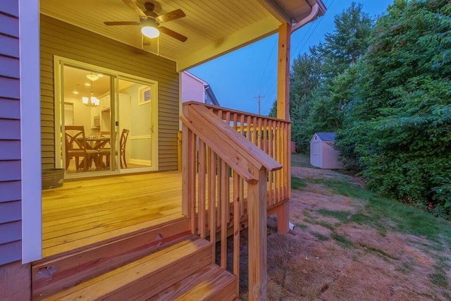 wooden deck with ceiling fan and a storage shed