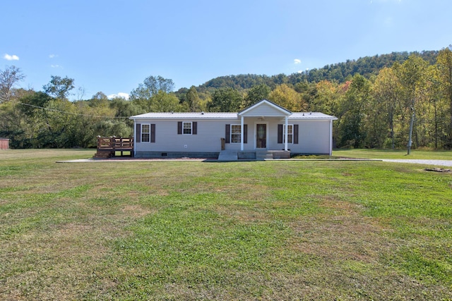 manufactured / mobile home featuring covered porch and a front lawn