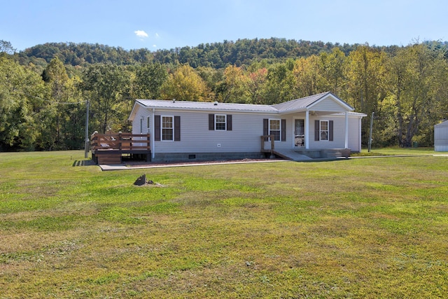 manufactured / mobile home featuring a deck and a front yard