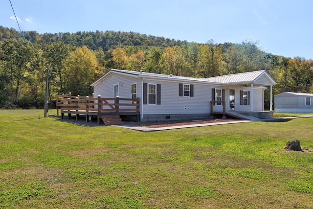 view of front of home with a deck and a front yard