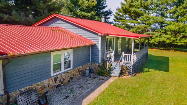 view of property exterior with a porch and a lawn