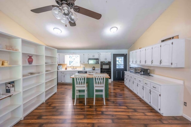 kitchen with a breakfast bar, ceiling fan, dark wood-type flooring, and white cabinets