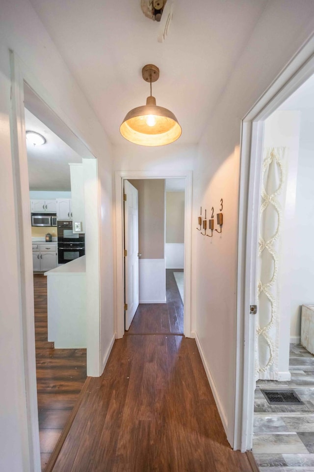 hallway with dark wood-type flooring