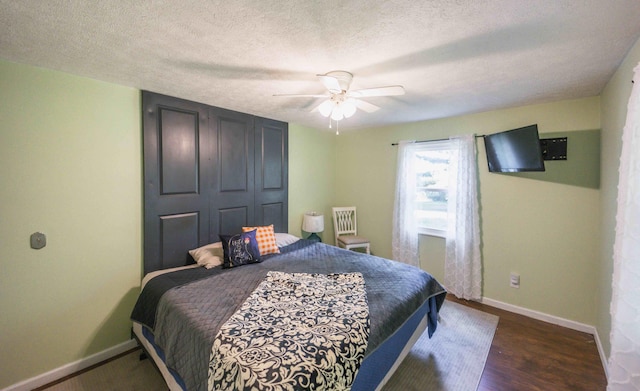 bedroom featuring a textured ceiling, ceiling fan, and dark hardwood / wood-style floors