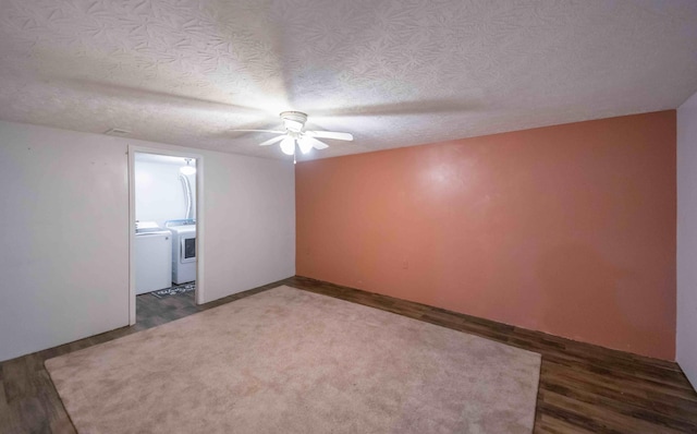 unfurnished room featuring washing machine and dryer, a textured ceiling, dark hardwood / wood-style floors, and ceiling fan