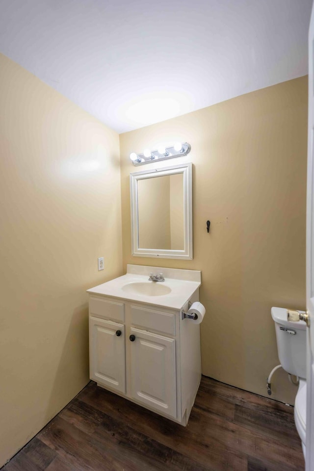 bathroom featuring toilet, wood-type flooring, and vanity