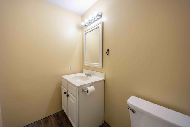 bathroom with toilet, vanity, and hardwood / wood-style flooring