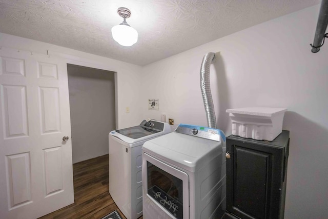 laundry area with washer and clothes dryer, a textured ceiling, and dark wood-type flooring