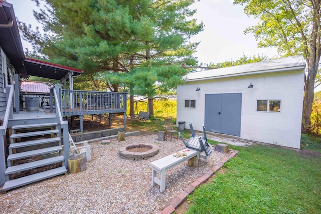 view of yard with an outdoor fire pit and a deck