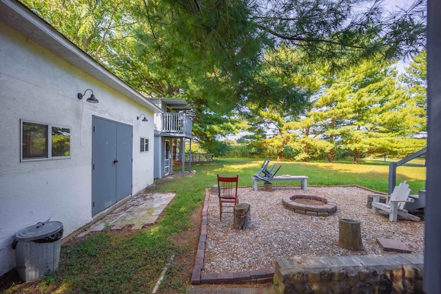 view of yard with a fire pit and a balcony