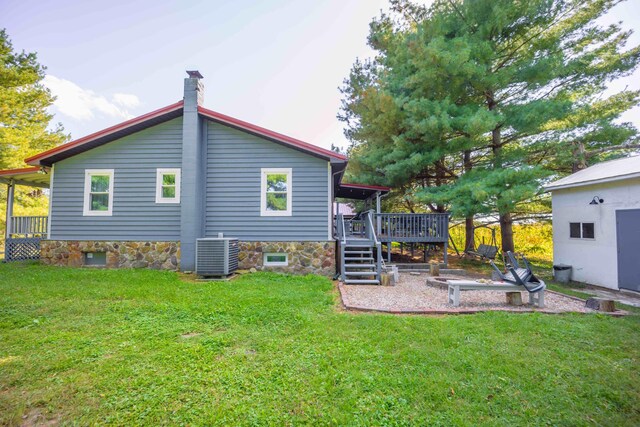 back of house with a deck, central AC unit, and a yard