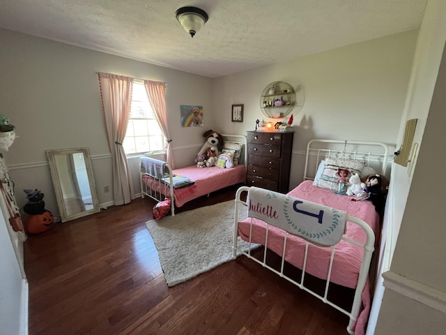 bedroom with dark wood-type flooring and a textured ceiling