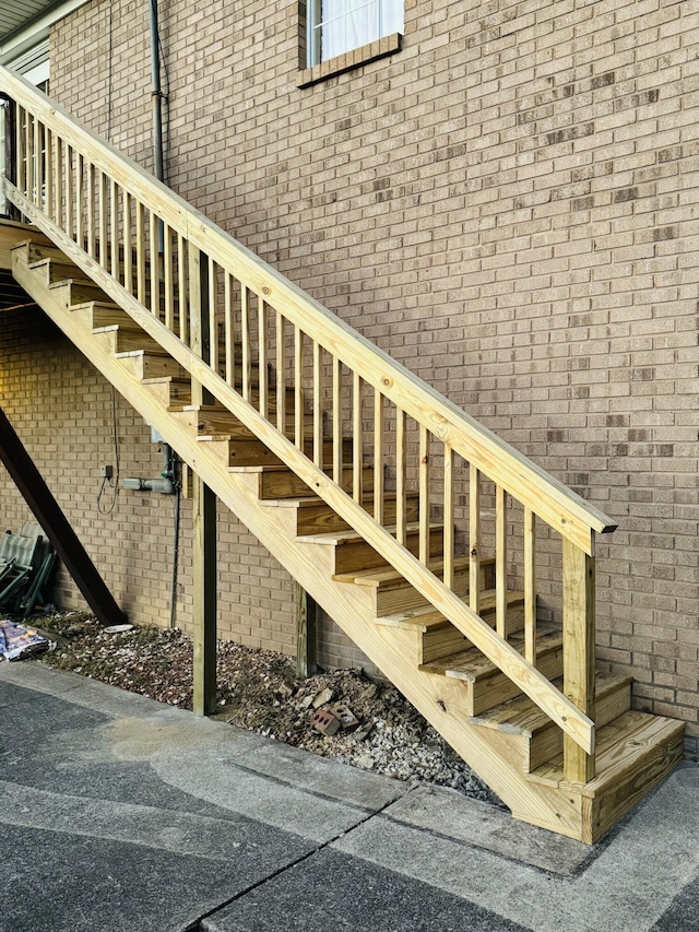 stairs featuring a towering ceiling and brick wall