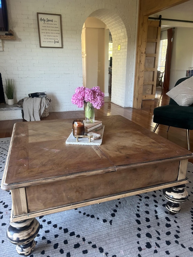 dining room with brick wall and hardwood / wood-style flooring