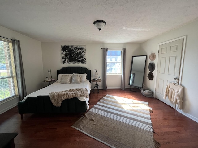 bedroom featuring a textured ceiling and dark hardwood / wood-style flooring