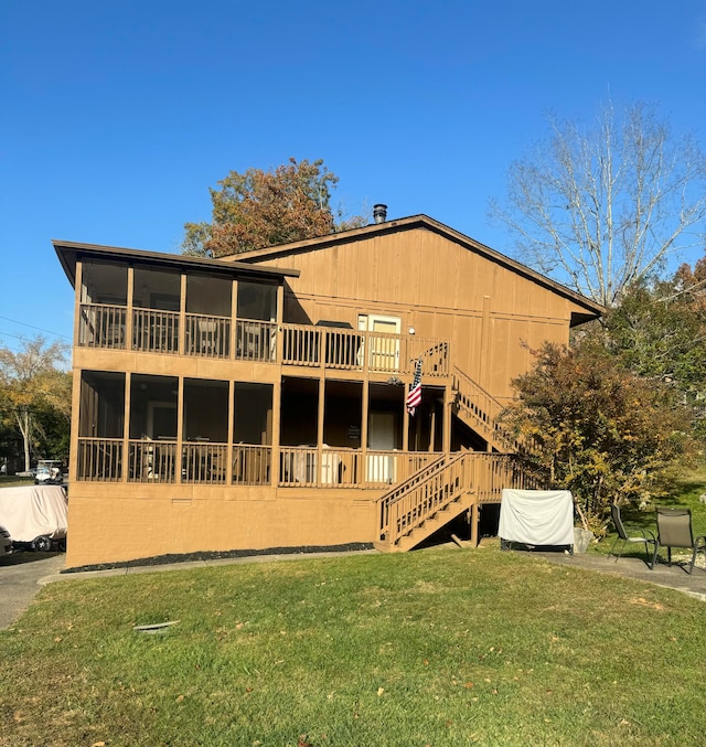 rear view of property featuring a lawn and a wooden deck