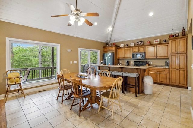 dining space featuring vaulted ceiling with beams, ceiling fan, light tile patterned floors, and wooden ceiling