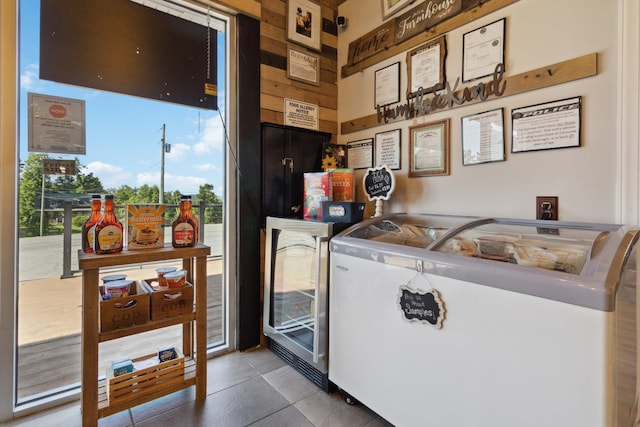 kitchen featuring wine cooler and wood walls