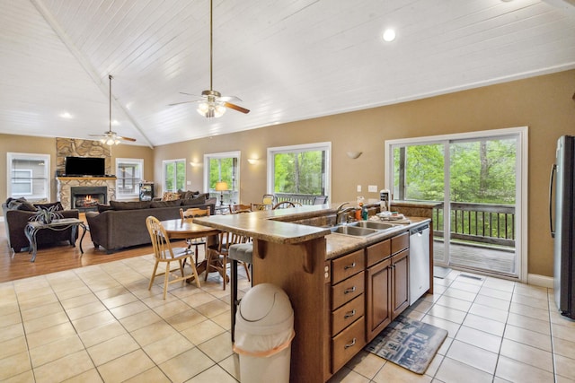 kitchen with a center island with sink, plenty of natural light, lofted ceiling, and appliances with stainless steel finishes