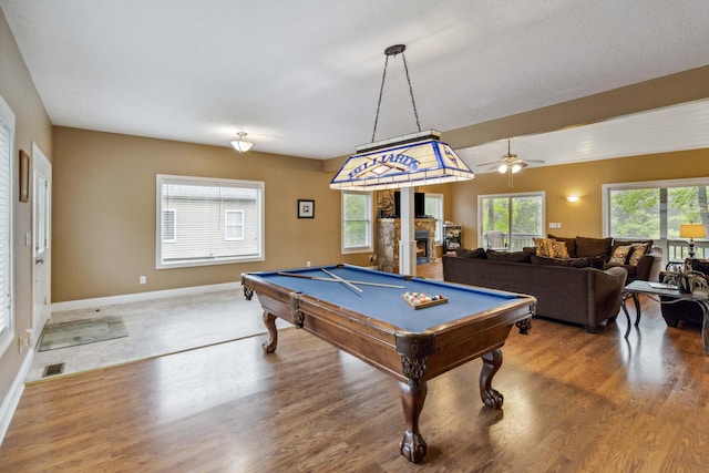 recreation room featuring a fireplace, wood-type flooring, ceiling fan, and pool table