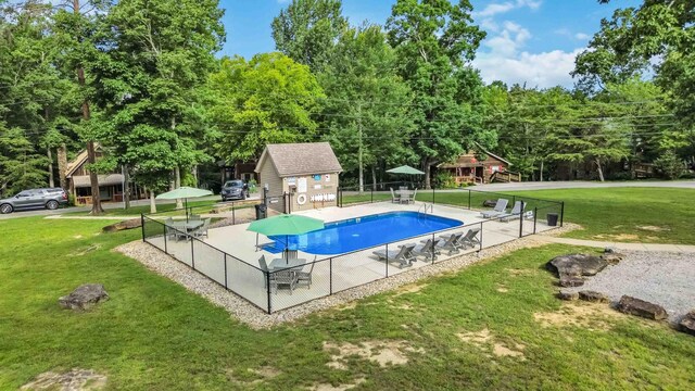 view of swimming pool with a yard and an outdoor structure