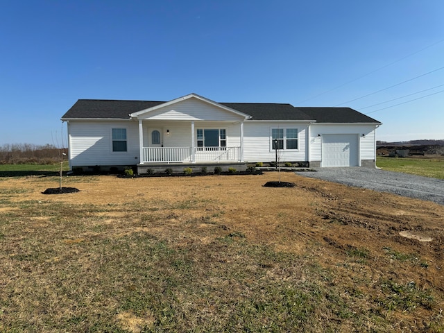 view of front of property with covered porch, a front yard, and a garage