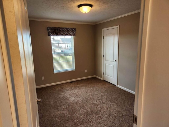 carpeted empty room with ornamental molding and a textured ceiling