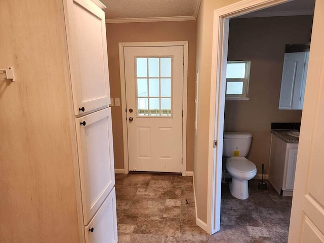 entryway with dark tile flooring and crown molding