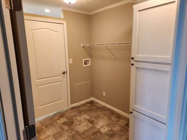 laundry area featuring a textured ceiling, ornamental molding, dark tile flooring, and hookup for a washing machine