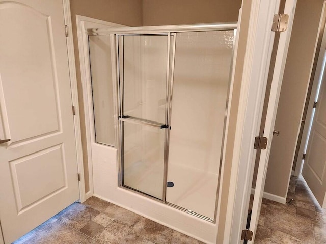 bathroom with tile flooring and a shower with shower door