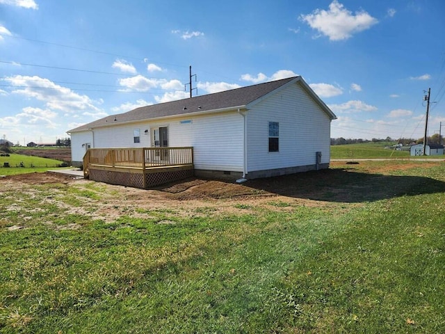 rear view of property with a yard and a deck