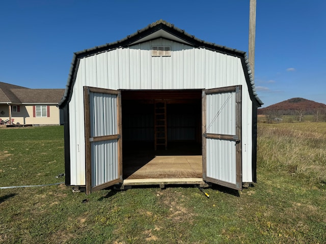 view of shed / structure with a lawn and a mountain view