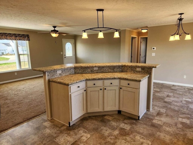 kitchen with decorative light fixtures, ceiling fan, a textured ceiling, dark tile floors, and light stone counters