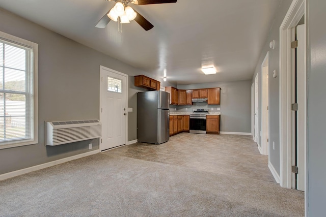 kitchen featuring ceiling fan, light carpet, stainless steel appliances, and a wall mounted air conditioner