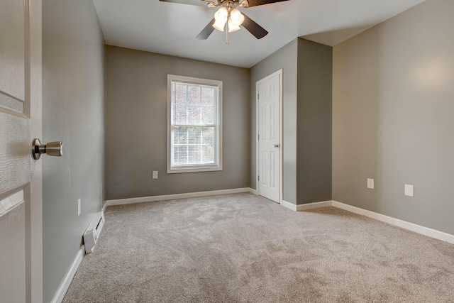 carpeted spare room with ceiling fan and a baseboard radiator