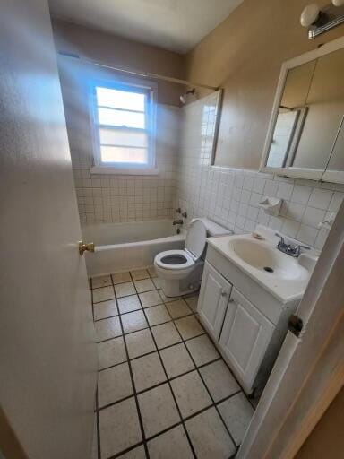 full bathroom with tile floors, backsplash, tiled shower / bath combo, vanity, and toilet