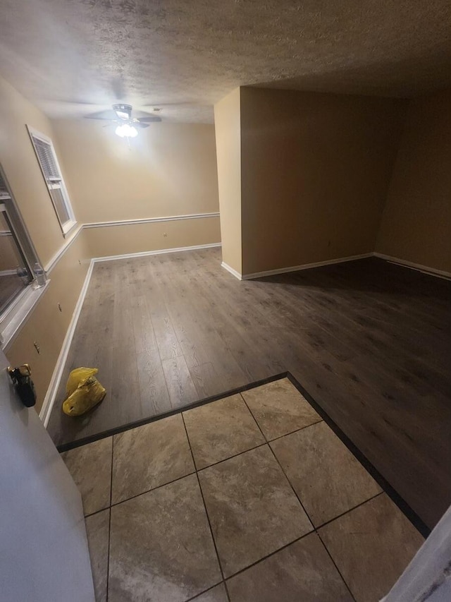 empty room featuring a textured ceiling, ceiling fan, and hardwood / wood-style floors