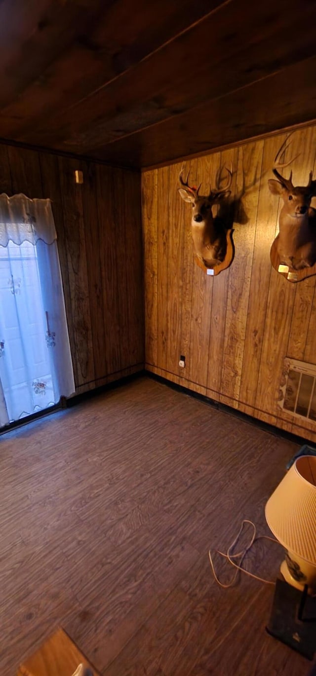 unfurnished room featuring dark hardwood / wood-style flooring and wooden walls