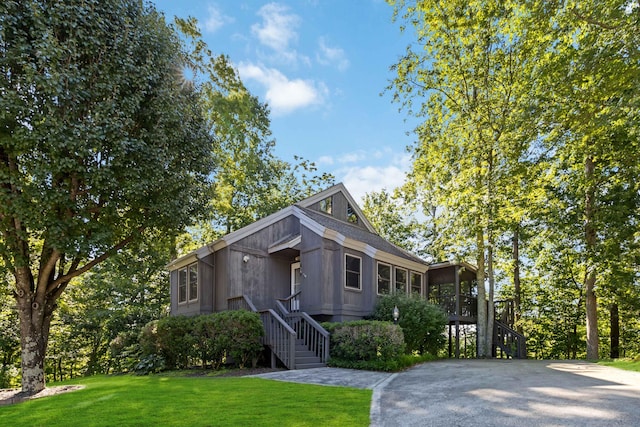 view of front of home featuring a front yard and a sunroom