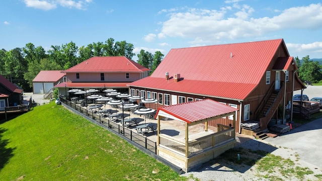 exterior space with stairway, metal roof, and a yard