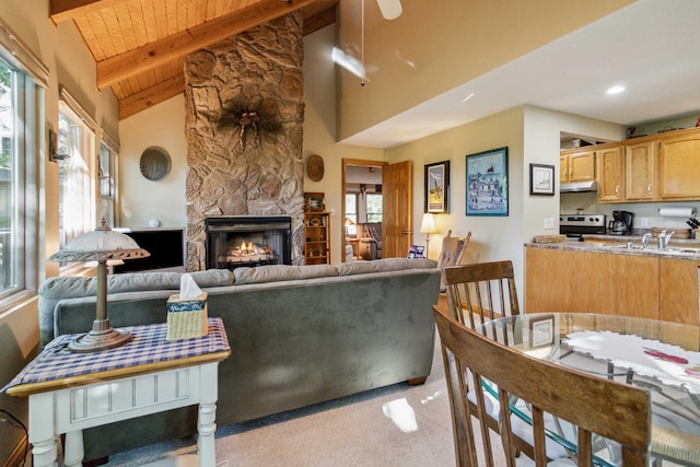 living room with wooden ceiling, high vaulted ceiling, a fireplace, beam ceiling, and light colored carpet