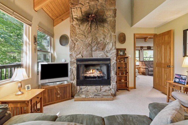 living room with a fireplace, light carpet, and high vaulted ceiling