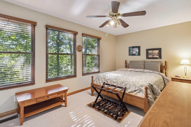 bedroom featuring carpet flooring, multiple windows, and ceiling fan