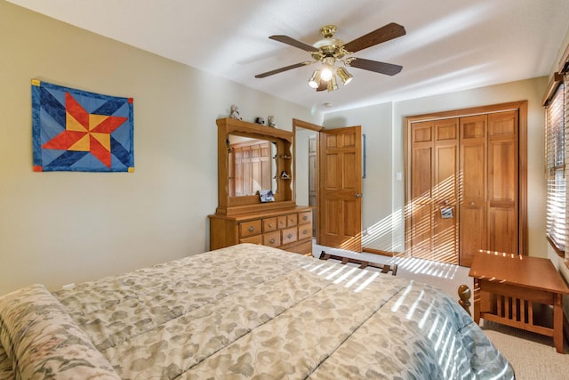 carpeted bedroom with ceiling fan and a closet