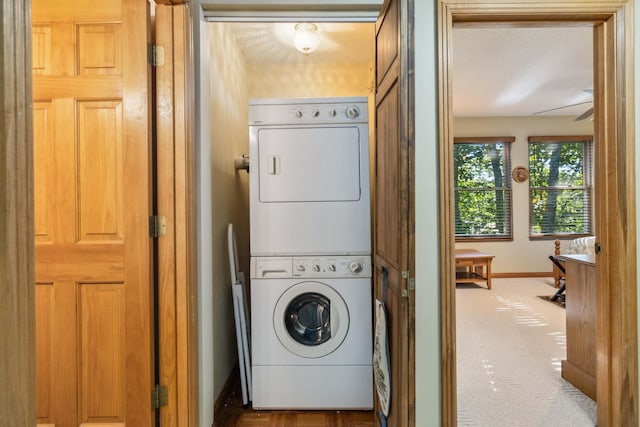 washroom with stacked washing maching and dryer and carpet floors