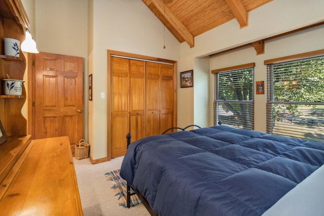 carpeted bedroom with wood ceiling, a closet, and lofted ceiling with beams