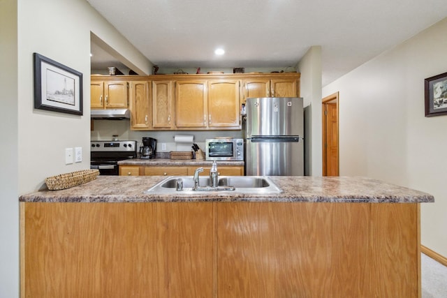 kitchen with under cabinet range hood, brown cabinets, a peninsula, stainless steel appliances, and a sink