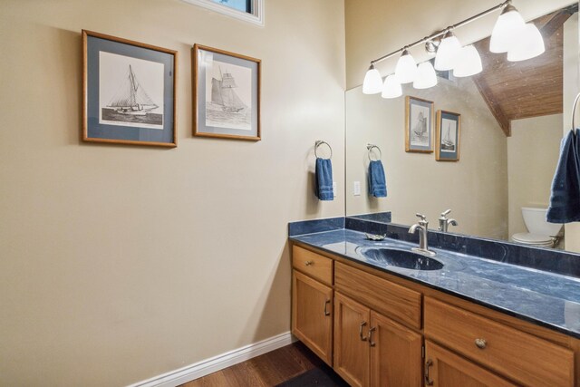 bathroom with wood-type flooring, vanity, and toilet