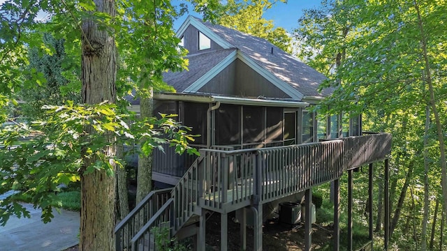 view of home's exterior with central AC unit, a wooden deck, and a sunroom