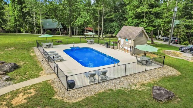 view of pool with an outdoor structure, a yard, and a patio